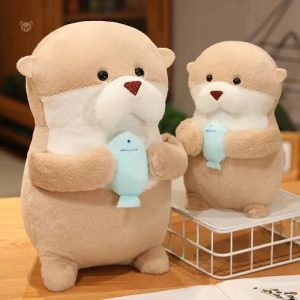 Peluche loutre tenant un poisson dans ses bras