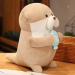 Peluche loutre joyeuse tenant un poisson dans sa patte