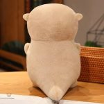 Loutre en peluche câline avec un poisson dans sa bouche
