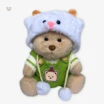 Ours en peluche en combinaison verte, parfait pour décorer une chambre