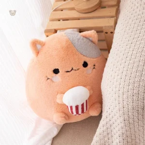 Mignonne peluche chat en train de déguster du popcorn