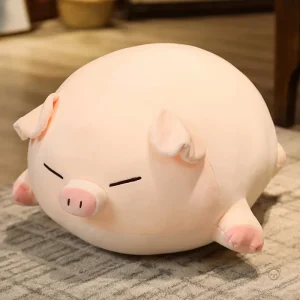 Peluche cochon allongé aux yeux fermés
