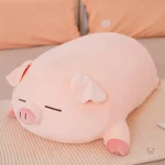 Peluche cochon rose allongé qui dort