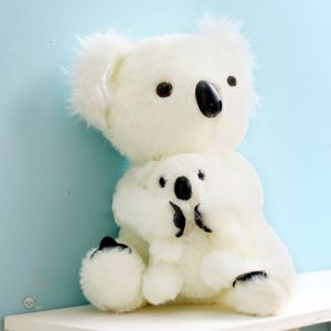 Koala mignon portant un bébé en peluche