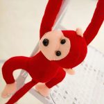 Peluche de singe avec queue rouge, parfaite pour câlins