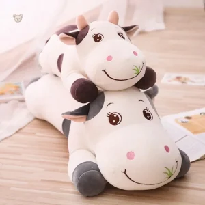 Peluche vache colorée qui broute de l'herbe